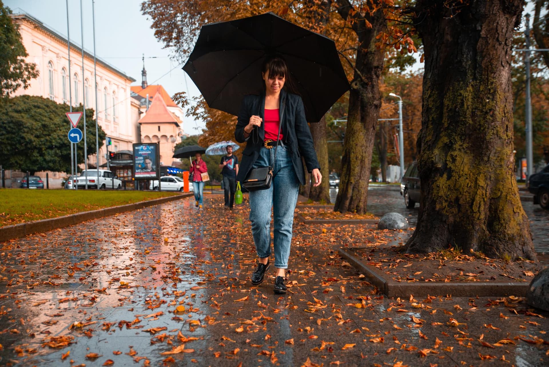 Napi őszi záporos időjárás napfénnyel, színes fákkal és tóval, réteges öltözékhez.
