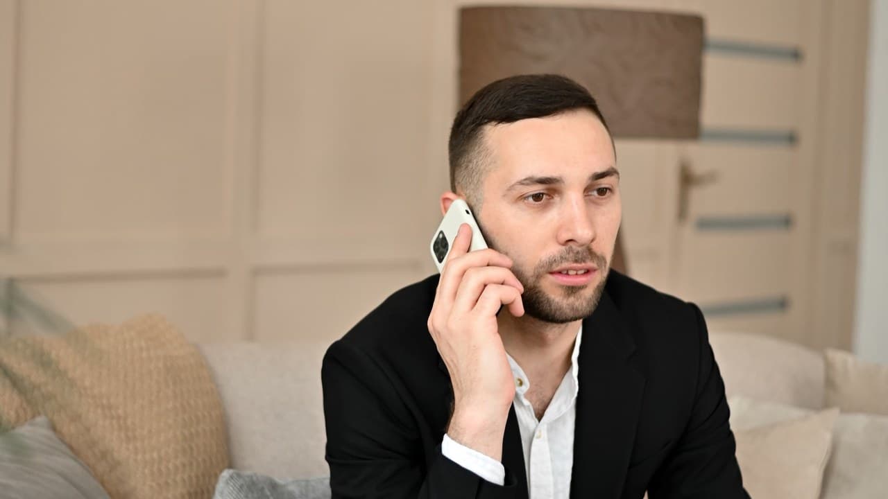 Egy nő telefonozik a kanapén, ami a kommunikáció és boldogságkutatás témáját illusztrálja. – 2. kép