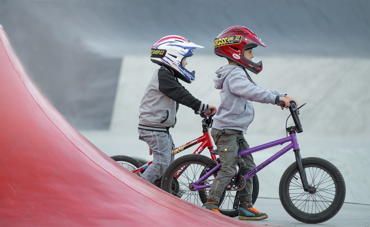 Két gyerek BMX-szel, akik a gyerekkori sport és a reziliencia témáját illusztrálják.