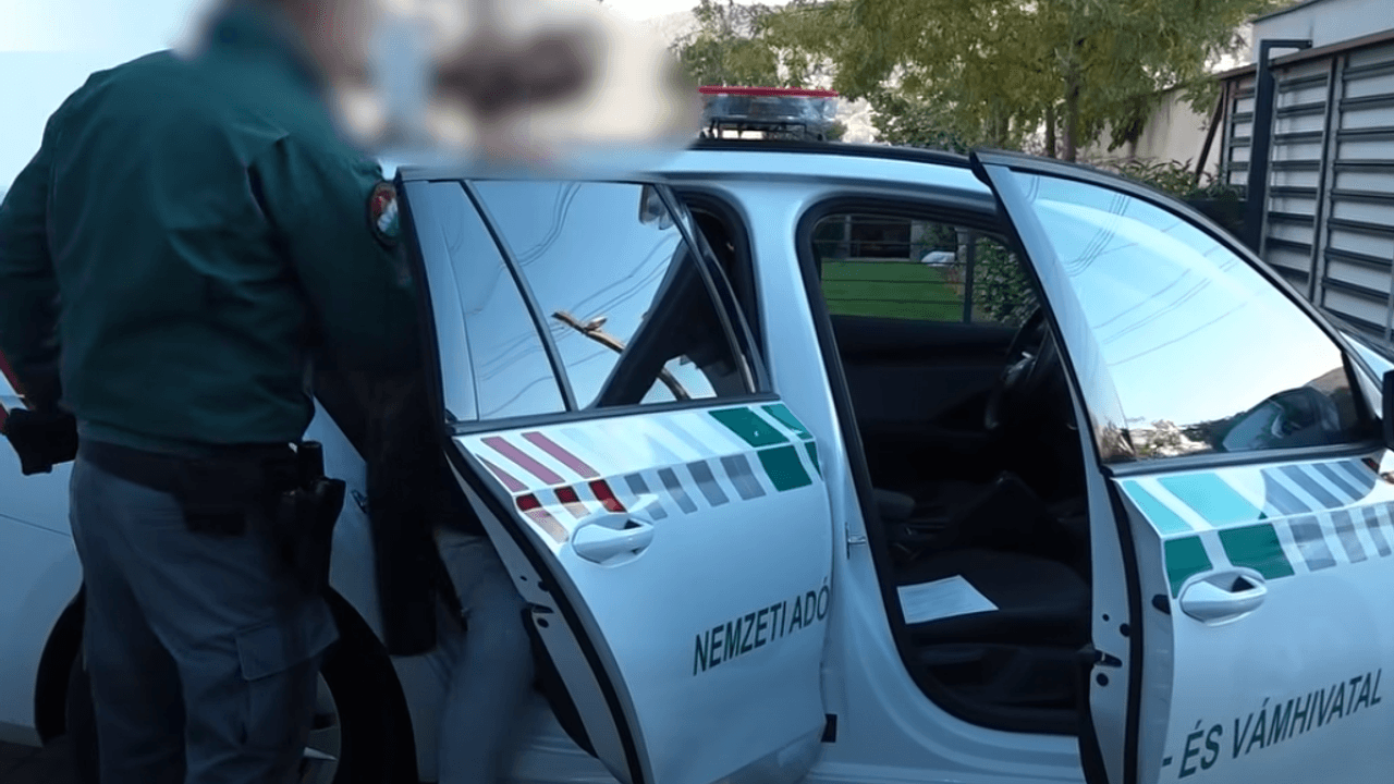 NAV-tisztviselő egy szolgálati autóba száll be a lélegeztetőgép-ügy kapcsán.