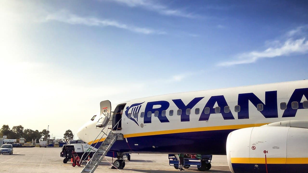 Utasokkal teli Ryanair repülőgép belseje, sárga ülésekkel és folyosóval.
